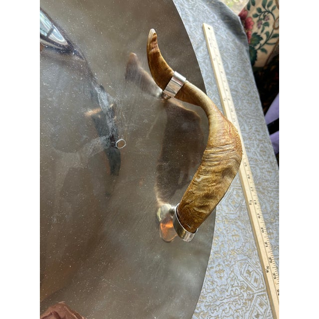 A large round serving tray with natural horn handle