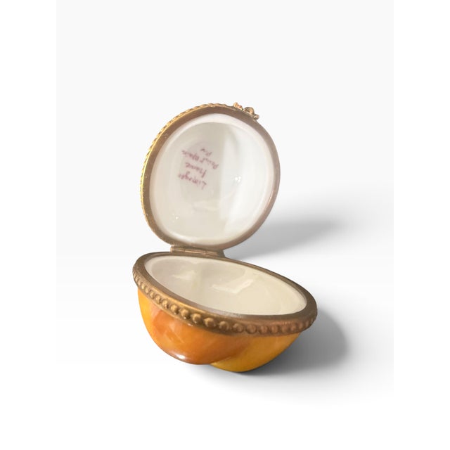 Bring a touch of French charm to your collection with this delightful hand-painted Limoges porcelain trinket box in the...