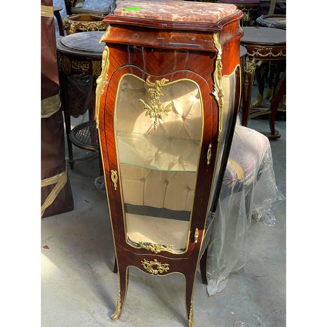 Showcase your treasured decorative objects in this charming French-inspired display vitrine. Featuring a rich reddish-...