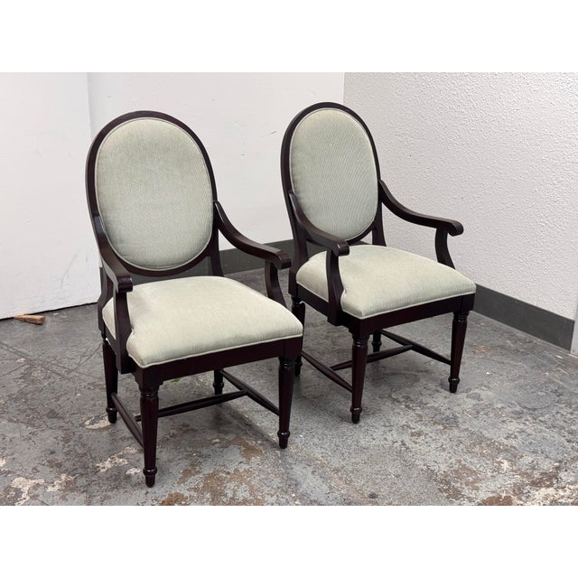 Design Plus Gallery presents a Pair of Oval-Back Dining Armchairs by Bernhardt Furniture. Each chair has a mahogany-toned...