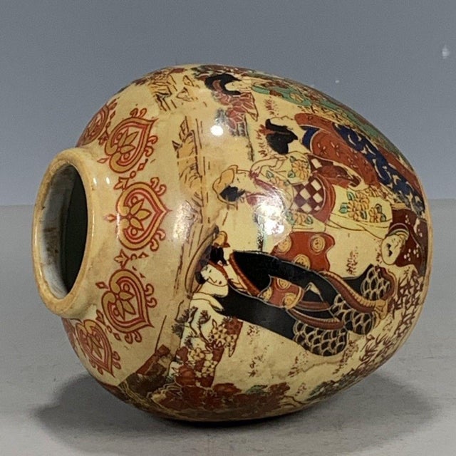 This round lidded jar is crafted in classic Japanese Satsuma style. The cream aged ground is decorated with a vibrant...