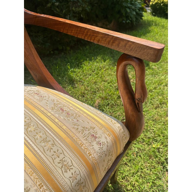 An exceptional French Empire settee dating to the early 19th century, crafted in richly figured mahogany and ornamented...