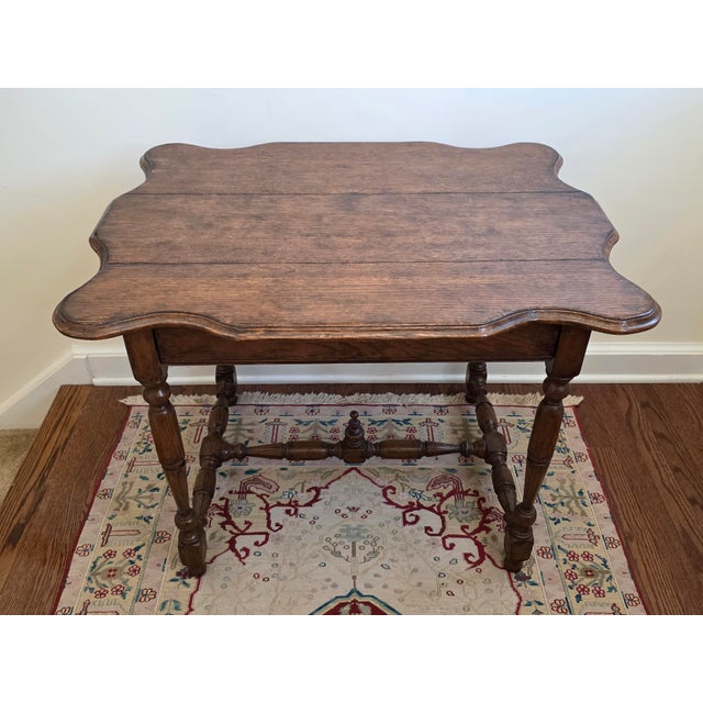 Beautiful solid wood table styled after a 17th century William and Mary English Oak table with scalloped-edge top and a...