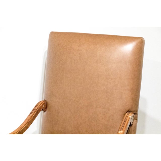 An elegant, caramel-colored Louis XIV style leather upholstered armchair with a straight, high back, distinctively...