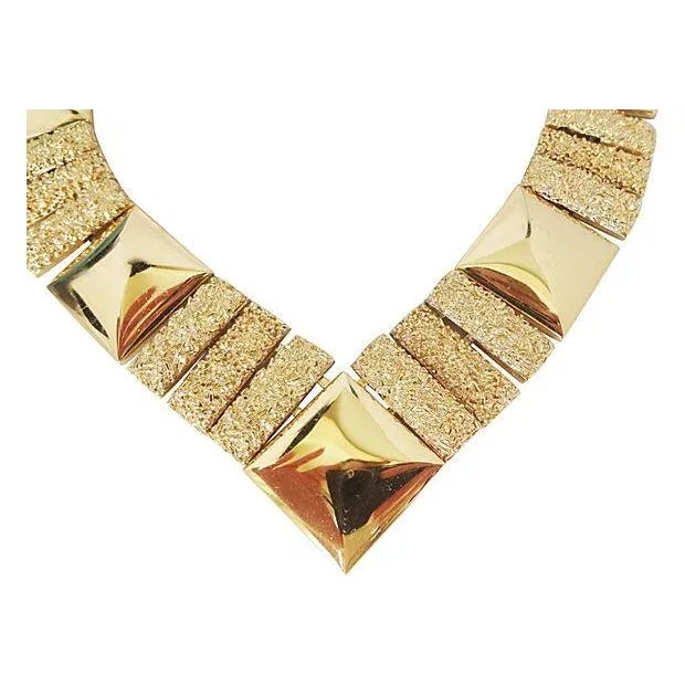This is part of Chairish’s Costume Jewelry assortment. Goldtone V necklace with nugget and shiny sugarloaf-shaped links...