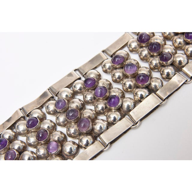 This hand wrought gorgeous and early Mexican hallmarked mid century modern cuff bracelet of sterling silver and amethyst...