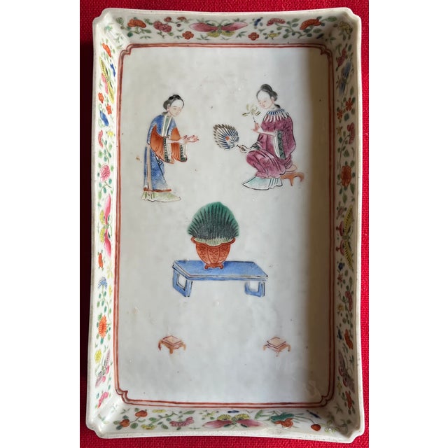 Chinese export famille rose porcelain rectangular tray raised on four shaped feet. Decorated with courtly women in a...