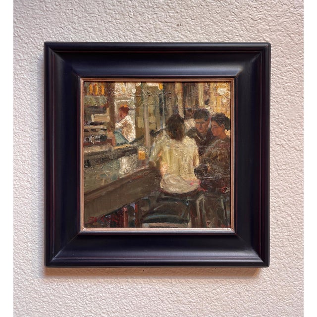 This oil on canvas painting captures a warm, intimate moment in a kitchen setting, where figures engage in quiet...