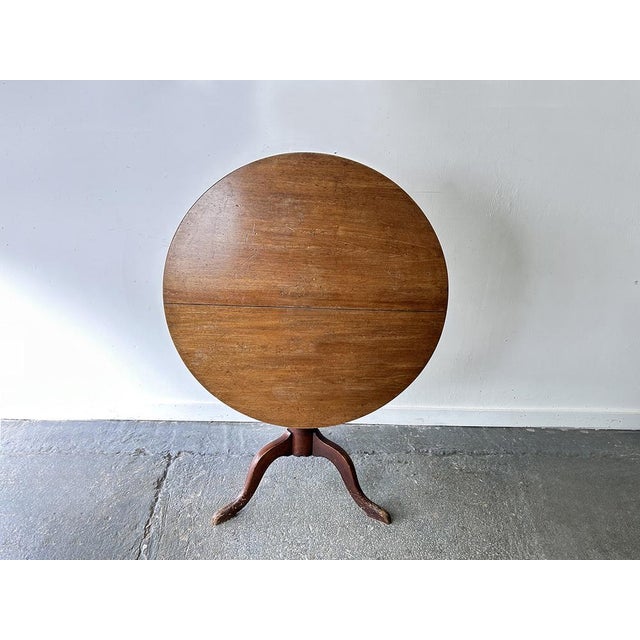 Antique English Georgian oak tilt-top tripod table, circa 1780–1820. Featuring a circular two-board top, turned pedestal,...
