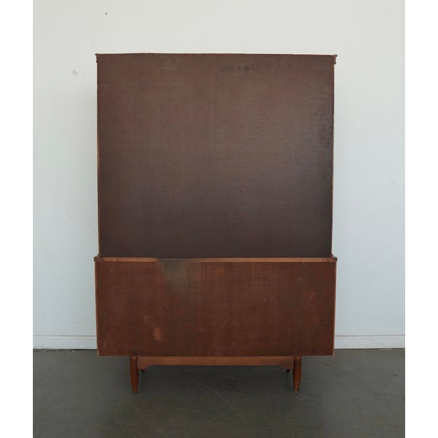 Vintage Mid Century Modern china cabinet by Garrison Furniture Co., showcasing the brand’s signature clean lines, warm...