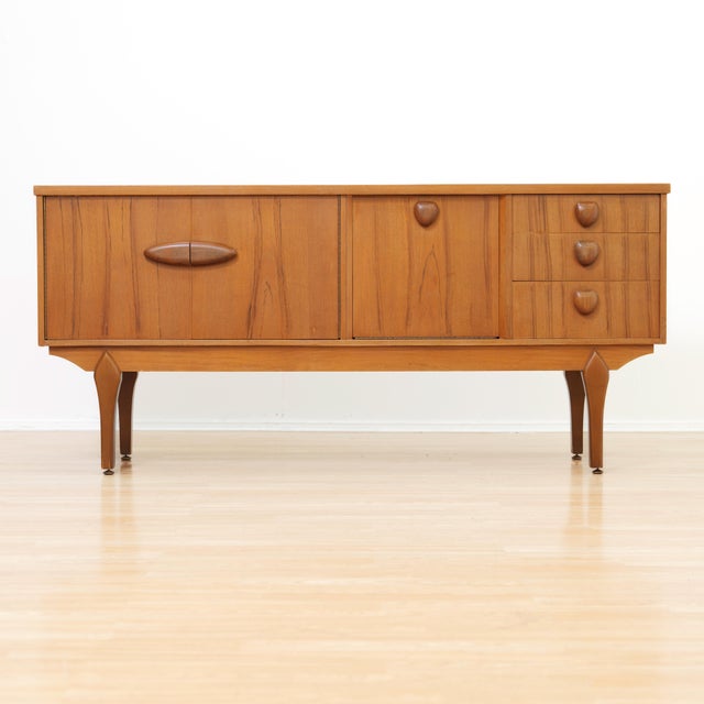 Designed and manufactured by Jentique Furniture, this elegant mid-century sideboard is crafted in beautifully figured teak...