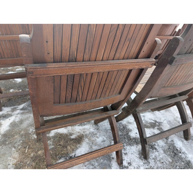 Discover a remarkable piece of American history with this complete, matching set of 12 antique folding theater chairs....