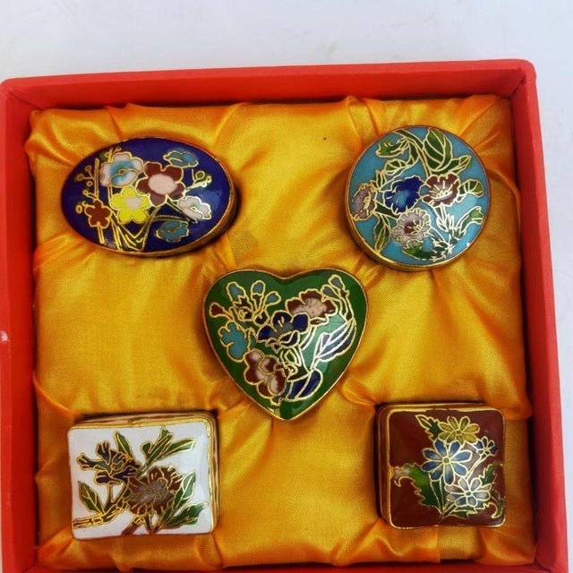 This is a charming set of five vintage cloisonné enamel miniature boxes, presented together in a red, fabric-lined...