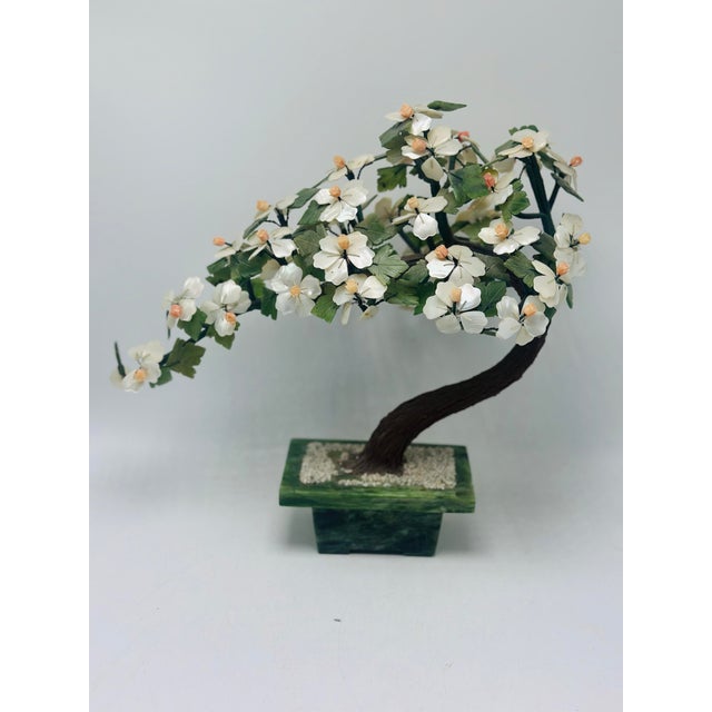 This piece is a vintage hardstone bonsai-style sculpture, crafted as a stylized flowering tree mounted in a carved stone...
