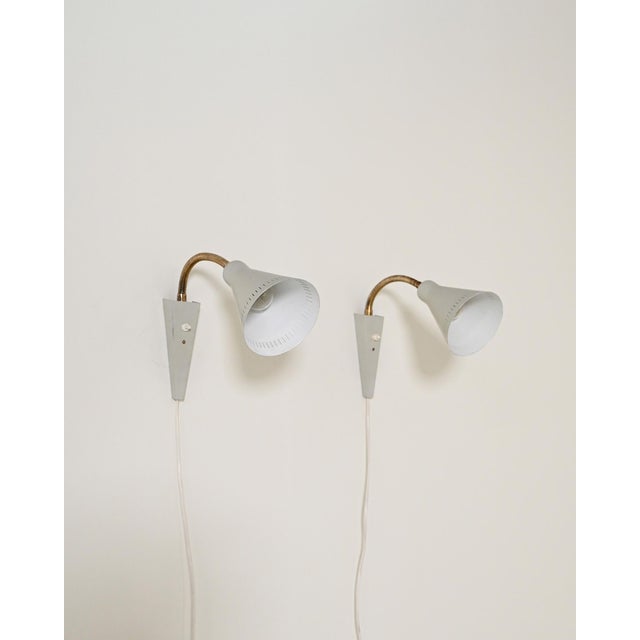 Pair of lacquered metal wall lamps with flexible brass arms and adjustable diffusers. Mae v-6 and semko markings present....