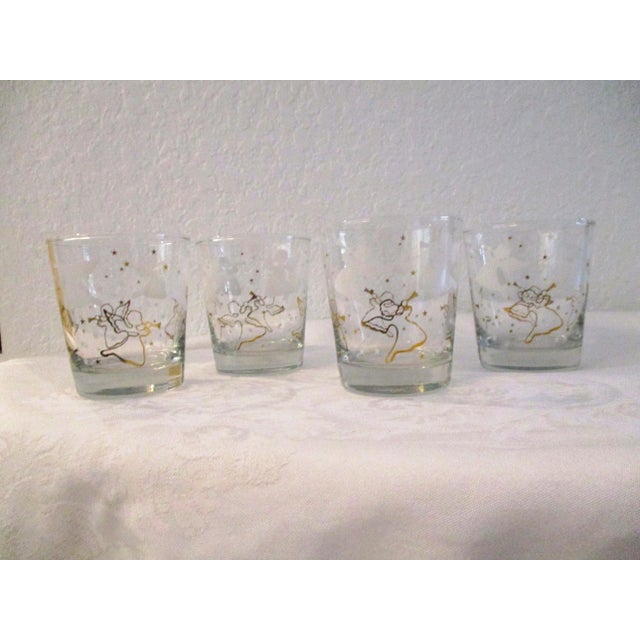 Lovely set of four clear glass lowballs featuring a Herald angel and star design around perimeter in white and gold. Thick...