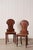 Pair of Victorian hall chairs with carved floral backs, shaped seats, and a warm aged finish. Classic English design with...
