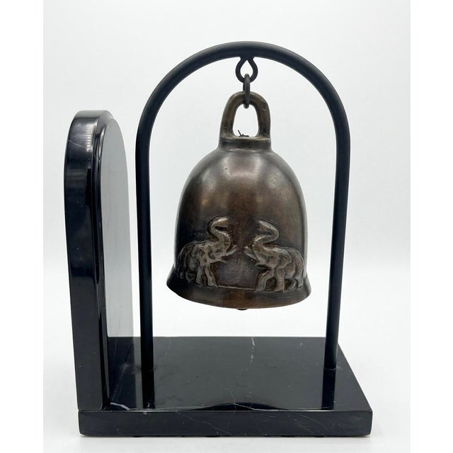 Vintage bronze elephant bells bookend with cast relief designs of working elephants on the bell surfaces and mounted on...