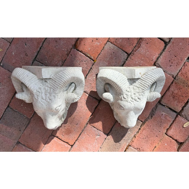 Pair of vintage cast stone wall shelves. Rams heads with flat rectangular surface above. Can be used outdoors, on a porch,...