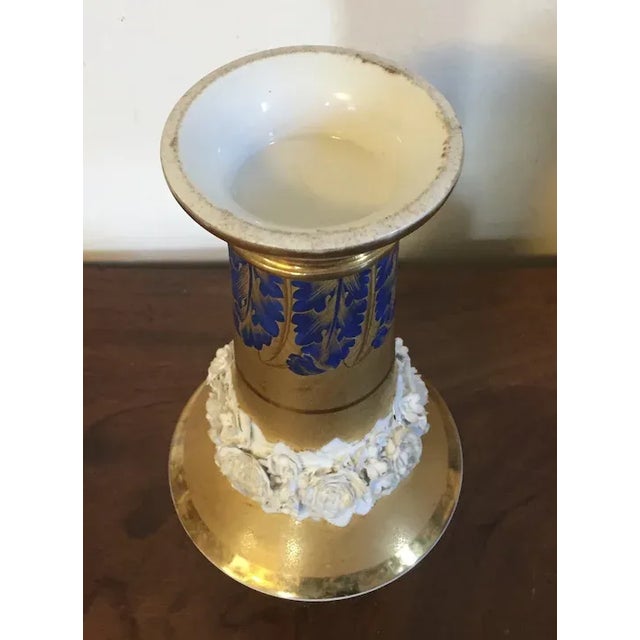 Antique early 19th c. French Empire Paris porcelain gold trumpet vase. Decorated with bright blue leaves at the base and...