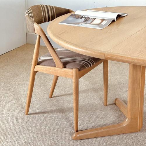 A refined circular double-extending dining table designed by Laurits M. Larsen and crafted in Denmark during the 1960s ....