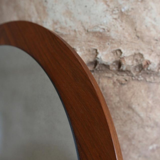 Round wall mirror with a wide teak veneer frame, mounted in a herringbone pattern: four diamond shapes positioned at the...