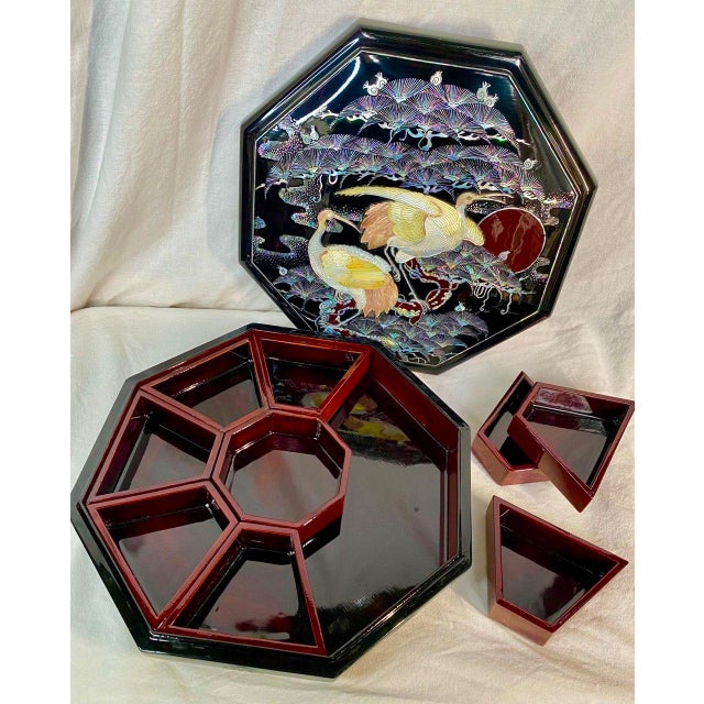 An exceptional Korean lacquered banchan box in a deep oxblood finish, richly inlaid with mother-of-pearl cranes beneath...