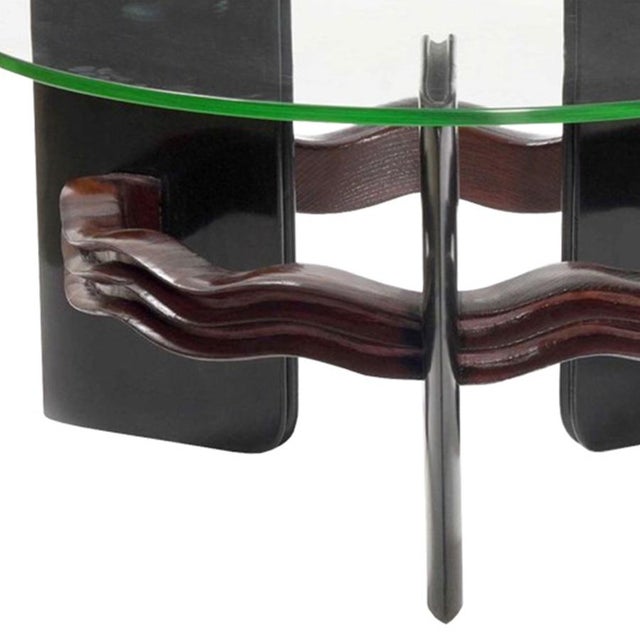 This Italian coffee table features three ebonized legs with curved wood stretcher connecting the legs. The wood stretcher...