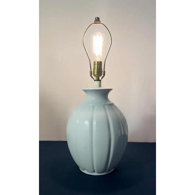This sculptural table lamp features a high-gloss periwinkle finish over a deeply fluted, melon-ribbed ceramic body. The...