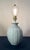 This sculptural table lamp features a high-gloss periwinkle finish over a deeply fluted, melon-ribbed ceramic body. The...