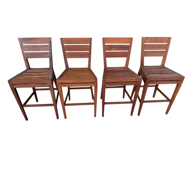 Elevate your outdoor kitchen, patio, or indoor bar area with this premium set of four solid teak barstools by renowned...