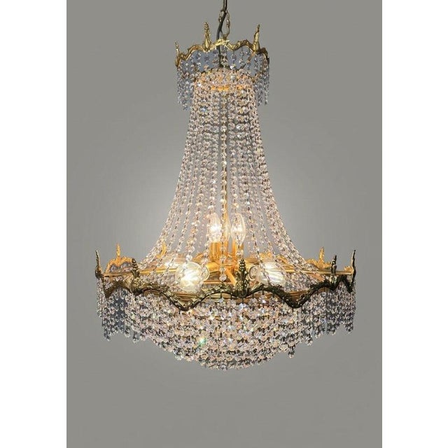 An exquisite Empire-style vintage French chandelier featuring a grand cascading silhouette and timeless elegance. Crafted...