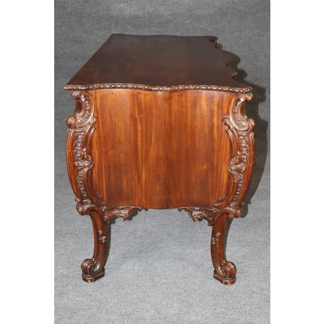 This extraordinary English mahogany serpentine commode, conceived in the grand Georgian tradition associated with Thomas...