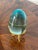 Vintage blue glass polished egg on gold brass tripod stand.