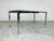 Mid-Century Modern chrome and tempered glass parsons style dining table by Tri-Mark having leather button straps that...