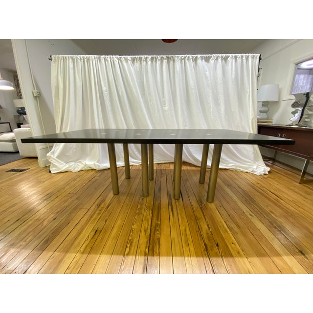 Brueton Ching dining table designed by Stanley Jay Friedman. Features eight cylindrical satin stainless steel legs...