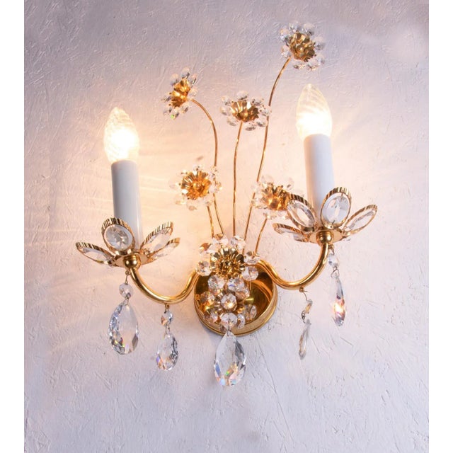 Elegant pair of wall sconces with a gold-plated brass frame and swarovski crystals. These lamps have an incomparable...