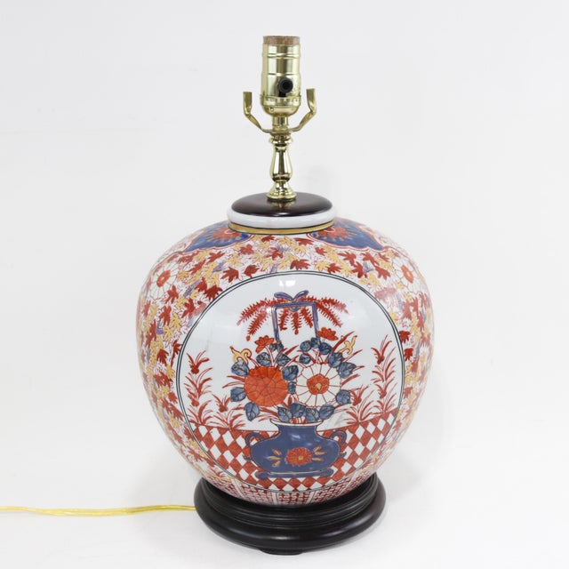 A stunning pair of Chinese porcelain lamps in the Imari style, showcasing intricate hand-painted floral arrangements in a...