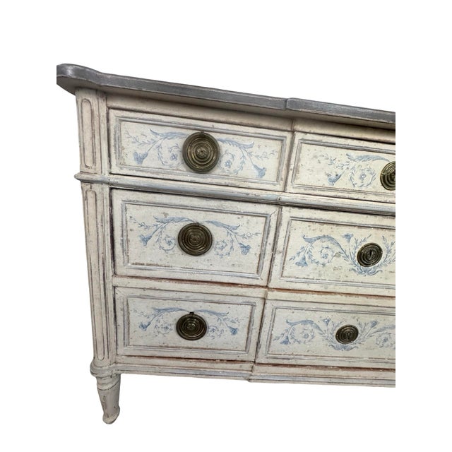 A striking late 19th-century French Neoclassical painted commode, imported from France, featuring a bank of nine drawers...