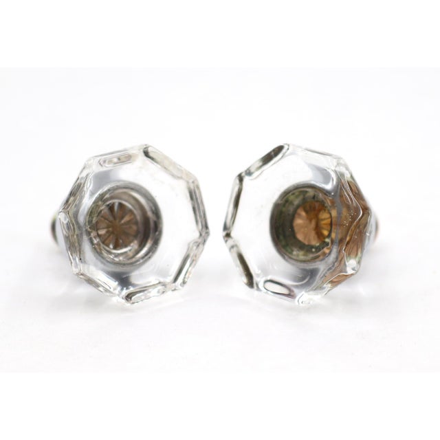 Vintage cabinet or drawer knobs made of clear glass with an octagon shape and chrome plated brass shanks. Mounting screws...