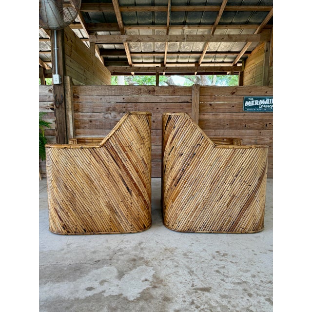 Striking set of two Mid-20th Century split rattan club lounge chairs with matching ottoman, fully restored and exuding...