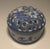 Two sweet lidded Chinoiserie hand painted porcelain boxes. The round box is painted with flora and topped with a pierced...