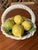 A sweet little Italian basket filled with glazed lemons in a bed of leaves. A perfect pop of color for your tablescape or...