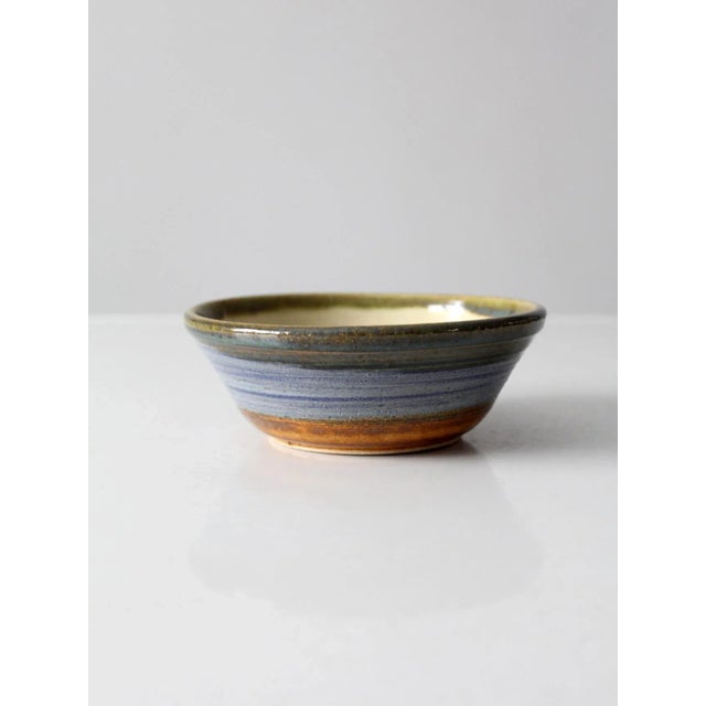 This is a vintage studio pottery bowl. Signed by the artist, Kulsea, the hand-crafted bowl features a stunning blue, tan,...