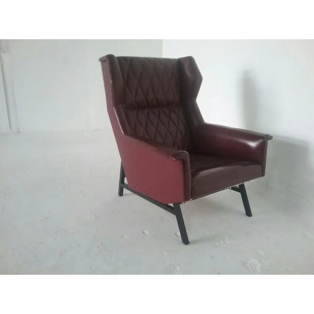 This Bordeaux-colored armchair dates from the 60s.