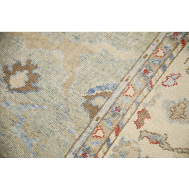 This modern Turkish Oushak rug is a stunning piece of art that has been handwoven using traditional techniques by skilled...