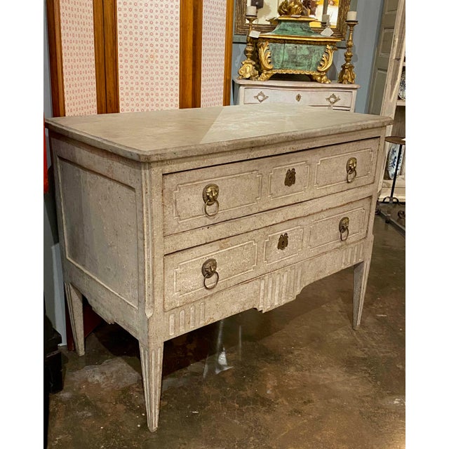 18th century Neoclassical carved and painted commode with original locks and brass lion head hardware. Circa 1775.