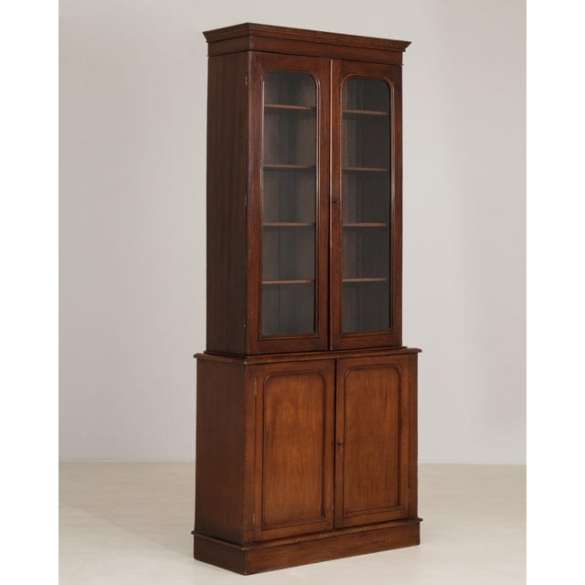 Glazed mahogany bookcase cabinet in Rich Mahogany. Its rich mahogany finish sets off two glazed doors, paneled cupboard...