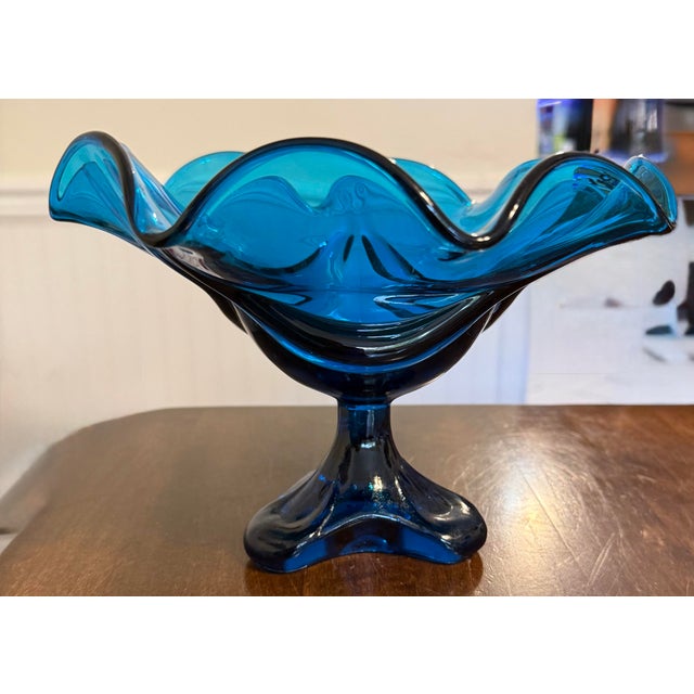This is a handmade vintage Viking Art Glass “Epic” compote distinguished by its vibrant “Bluenique” color, showcasing its...