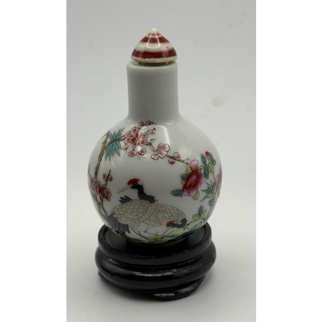 This is a beautifully painted porcelain bottle of a red crested crane under a tree of plum blossoms in full bloom. The...